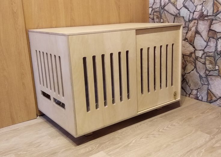 a wooden cabinet sitting on top of a hard wood floor next to a stone wall