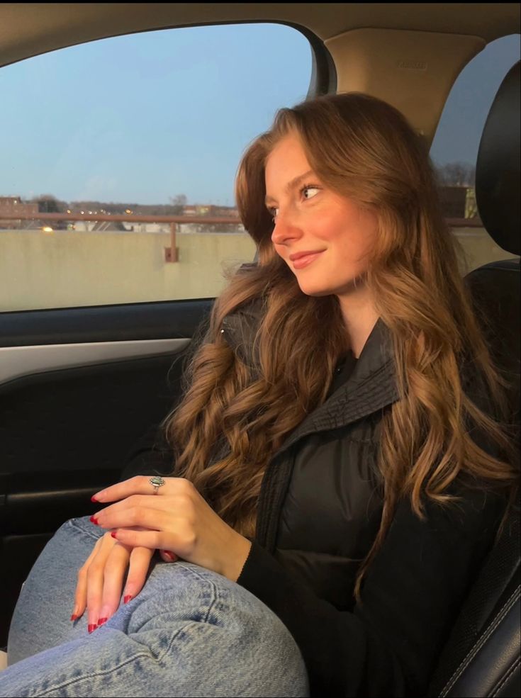 a woman sitting in the back seat of a car with her hand on her hip