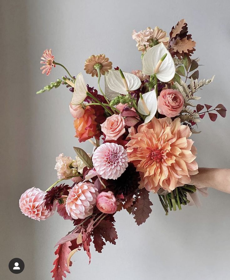 a person holding a bouquet of flowers in their hand