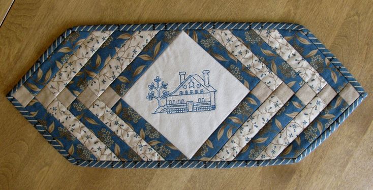 blue and white quilted placemats sitting on top of a wooden table