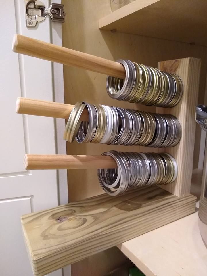 there are many different types of jars on the shelf in this kitchen rack, which is made out of wood and metal