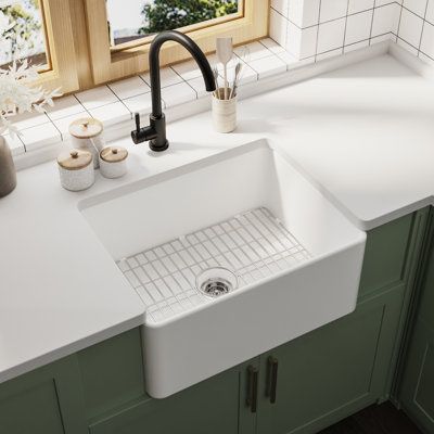 a white kitchen sink sitting under a window