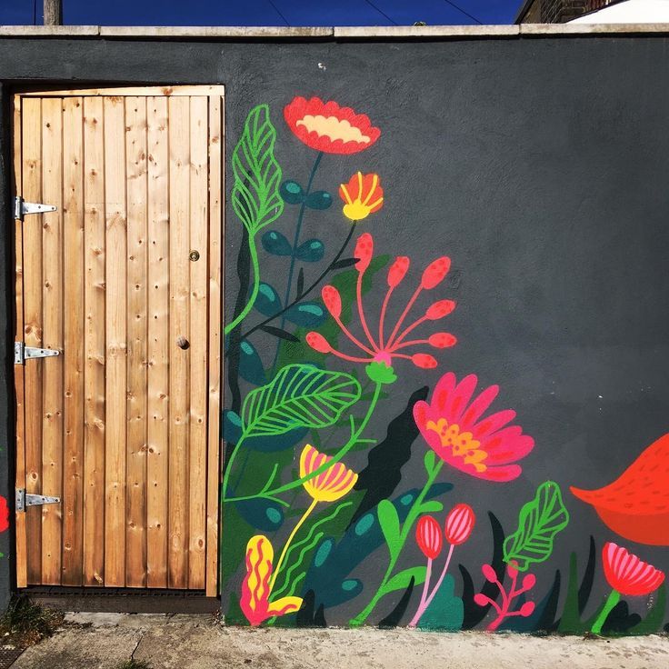 a painting on the side of a building with flowers painted on it's wall