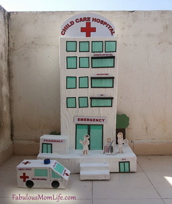 a toy hospital building with ambulances and medical supplies on the ground next to it