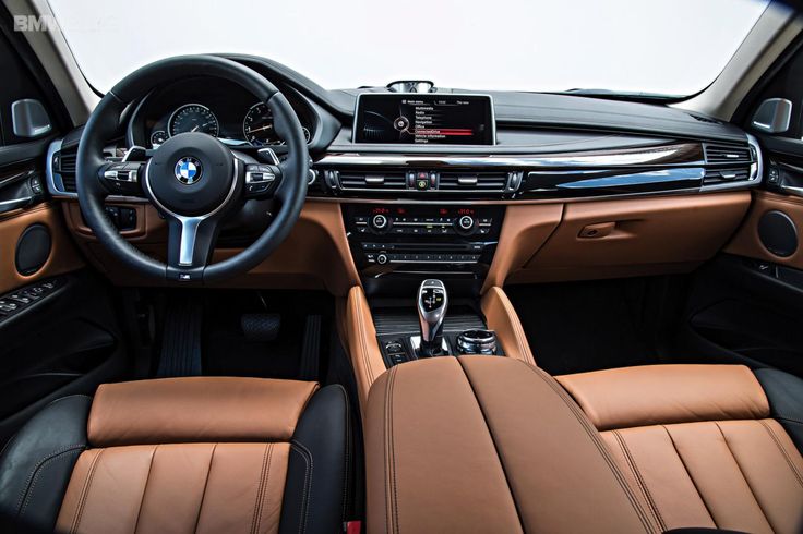 the interior of a bmw car with tan leather and black trims, including steering wheel