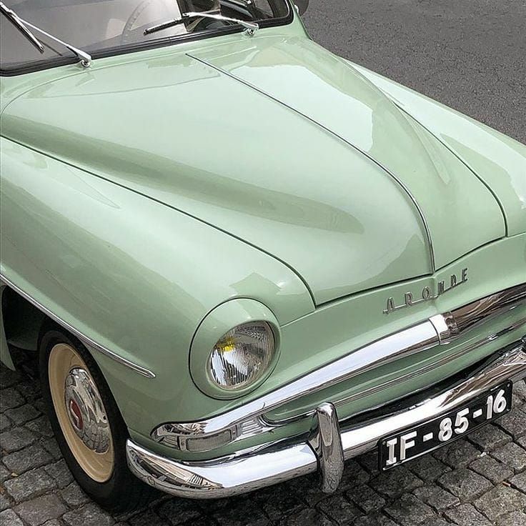 an old car is parked on the side of the road