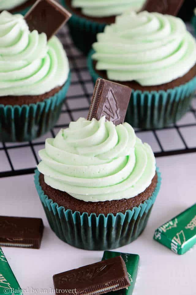 chocolate cupcakes with green frosting on cooling rack