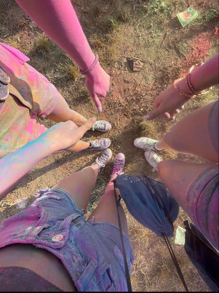 several people standing in a circle with their hands together