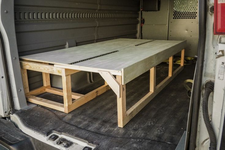 the back end of a van with a wooden table in it's cargo area