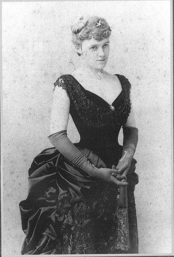 an old black and white photo of a woman wearing a dress with lace on it