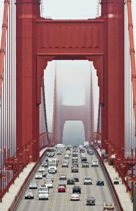 cars are driving over the golden gate bridge