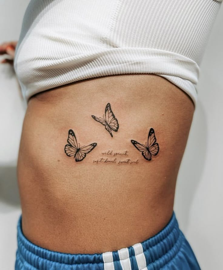 a woman's stomach with three butterflies on it