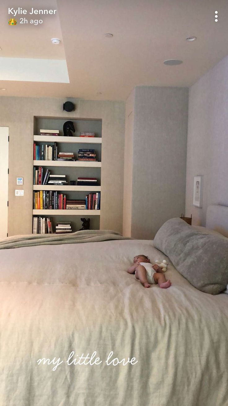 a bedroom with a bed, bookshelf and teddy bear on the floor in front of it