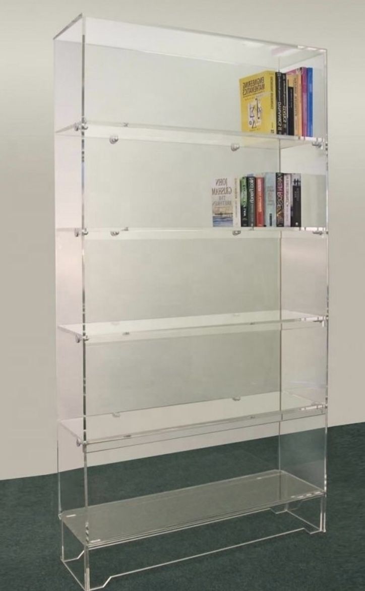 an acrylic book shelf with several books on top and two shelves below it