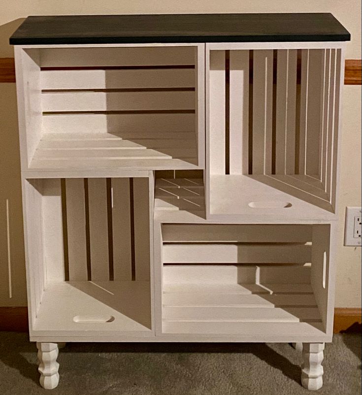 a white cabinet with black top and drawers