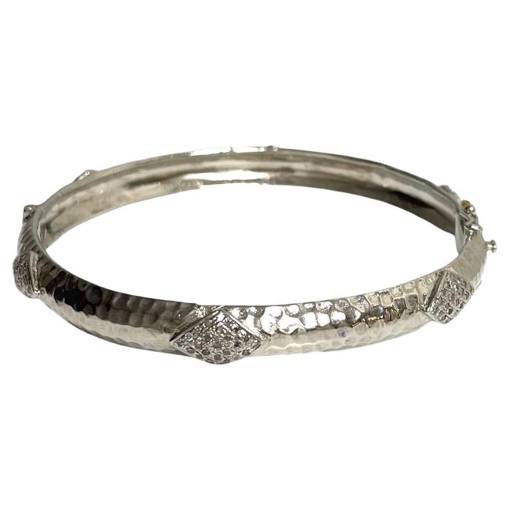 Description Your style comes to life wearing this unique, edgy and timeless sterling silver bracelet. Raised diamond shape appliques totaling 1.20 carats of pave diamonds encircle and embellish this stunning bangle. Artistically hammered by hand to create dazzling reflections when catching the light, it is sure to be a fashion-forward addition to your jewelry wardrobe. Along with its beauty, this hinged bracelet features a discrete and secure clasp. Item # B1221 If you prefer a wider bangle, see Silver Diamond Bracelet With Pavé Setting, Dazzling Sterling Silver Bracelets With Diamond Accents, Diamond White Sterling Silver Bracelet With Pave Setting, Modern Silver Diamond Bracelet With Pave Setting, Silver Cubic Zirconia Bangle With Pave Setting, Silver Pave Setting Bracelet, Silver Pave Setting Bracelet Jewelry, Silver Bracelet With Pave Setting, Silver Diamond Bracelet In Fine Jewelry Style