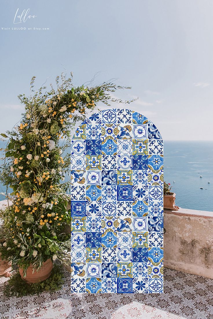 a blue and white tile covered wall next to a potted plant on a balcony