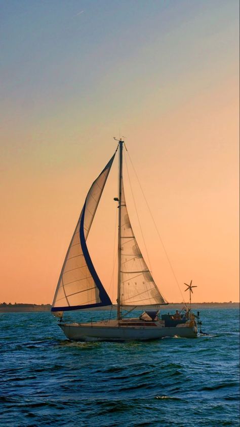 a sailboat sailing in the ocean at sunset