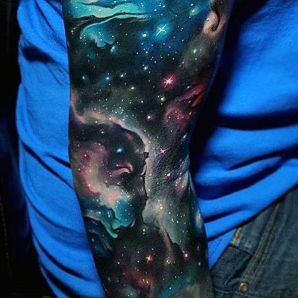 a man's arm covered in space and stars