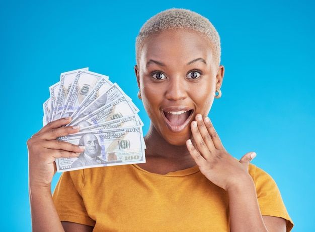 a woman holding money in one hand and making a funny face