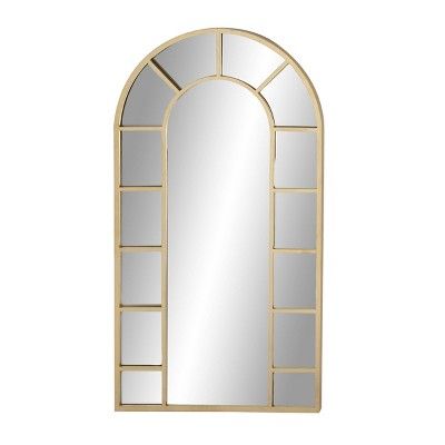 an arched mirror on a white wall with a gold frame and window panes in the middle