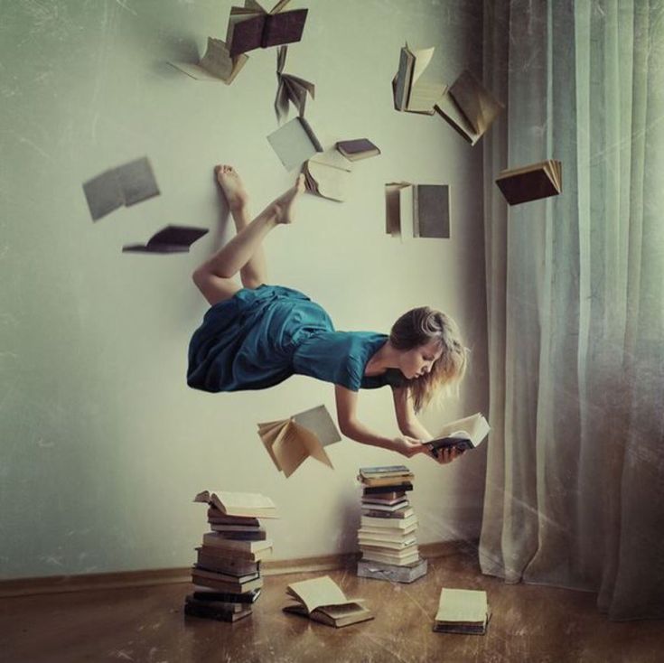 a young woman is jumping over books in the air with her legs spread wide open