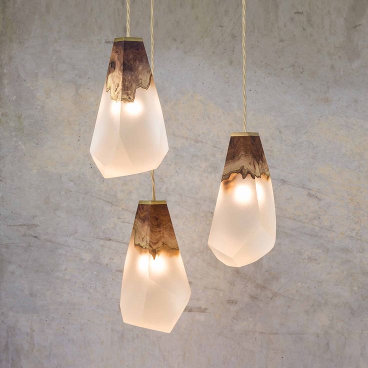 three light fixtures hanging from a concrete wall