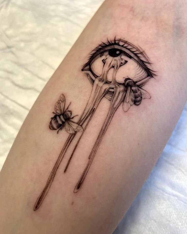 a woman's leg with tattoos on it and two forks in the shape of an eye