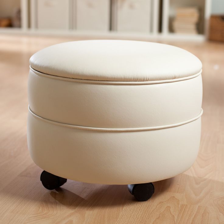 a white ottoman sitting on top of a hard wood floor