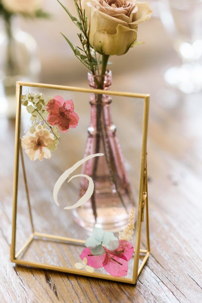 a vase with flowers in it sitting on a table next to a number six sign