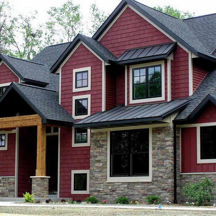 a large red house with two story windows and stone pillars on the front porch is shown