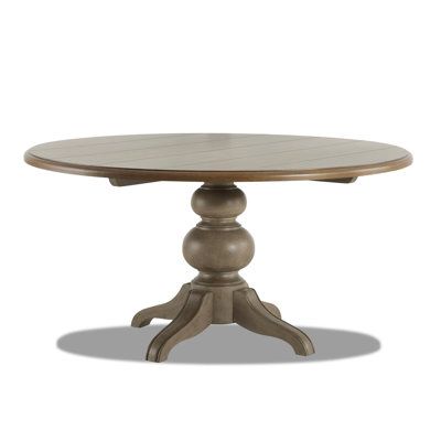 a round wooden table with two pedestals on each end and an oval base at the top