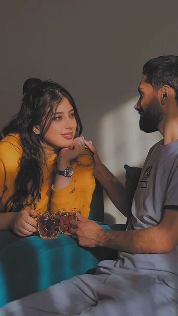 a man sitting next to a woman on top of a bed