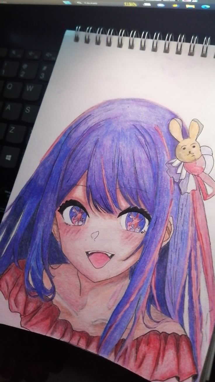 a drawing of a girl with purple hair and blue eyes is shown in front of a computer keyboard