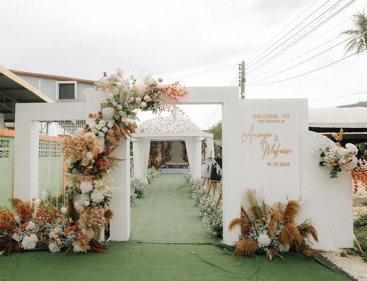 an outdoor wedding venue with flowers and greenery on the front entrance to the ceremony