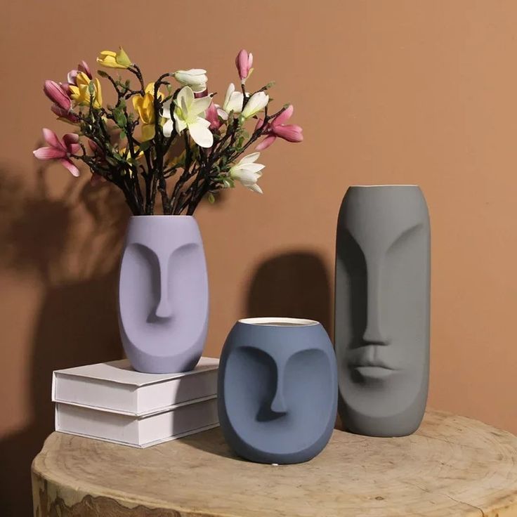 three vases with flowers in them sitting on a table