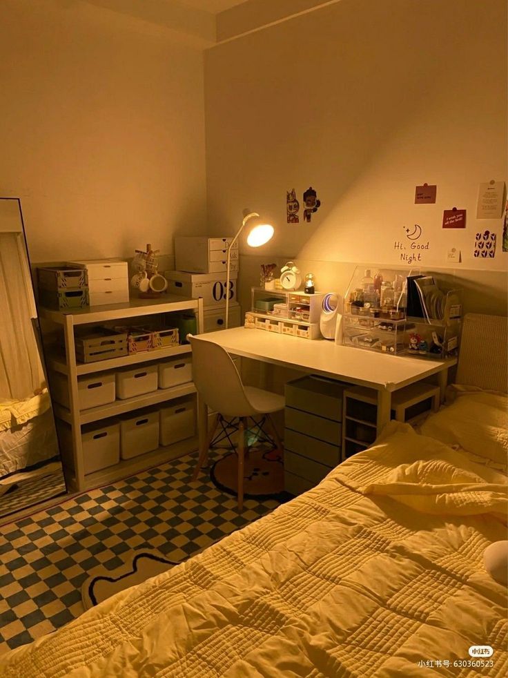 a bedroom with a bed, desk and mirror in it's corner next to a checkered floor