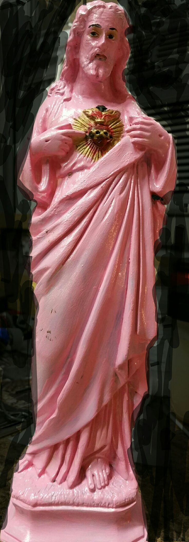 a pink statue is standing in front of a black background