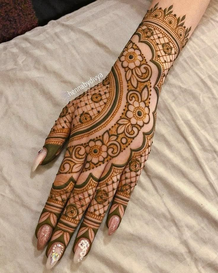 a henna on someone's hand that is sitting on a bed