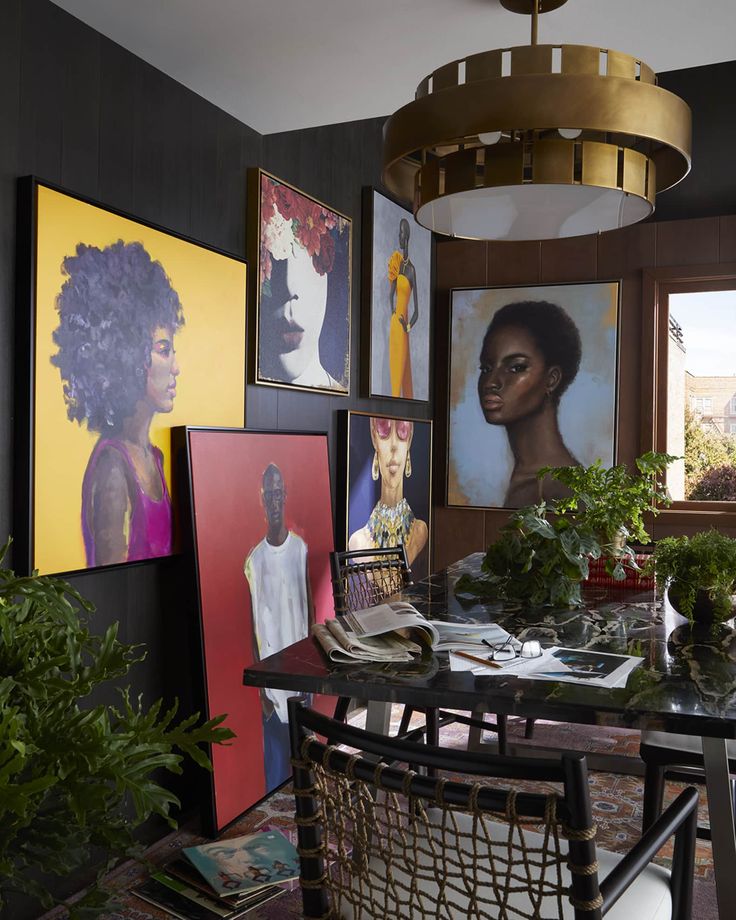 a dining room table surrounded by pictures and plants