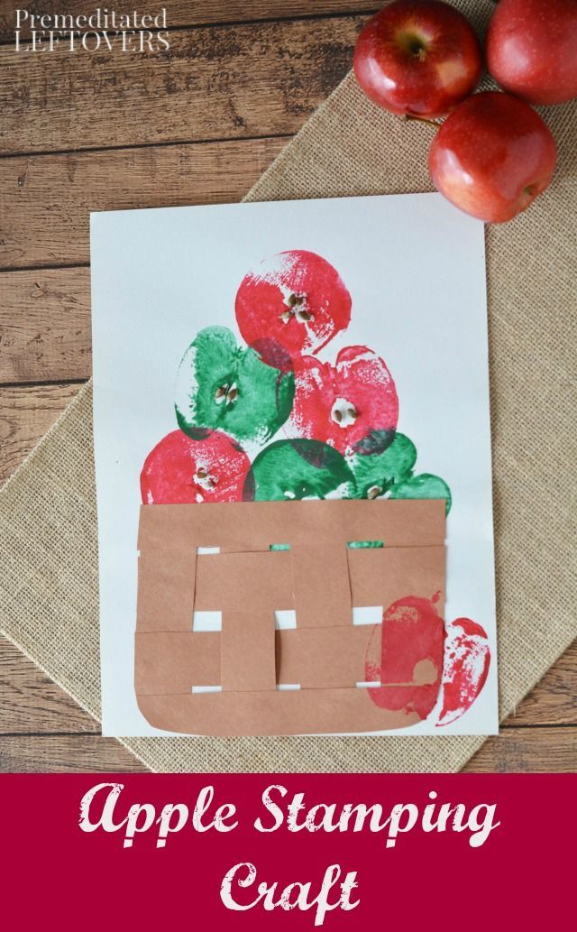 a paper bag filled with apples on top of a wooden table