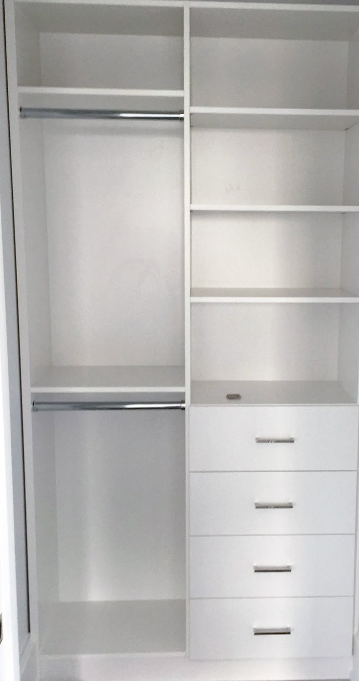 an empty white closet with drawers and shelves