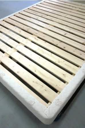 a bed frame made out of wooden planks with no mattress topper or headboard