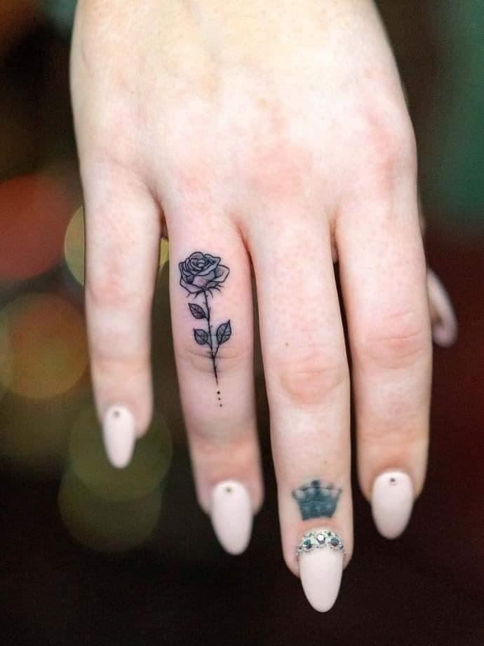 a woman's hand with a rose tattoo on it