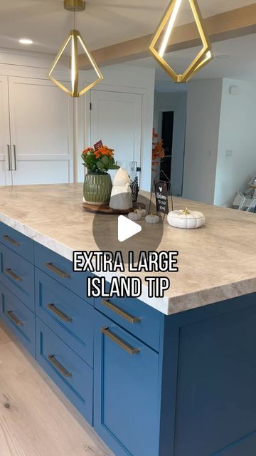 a large kitchen island with blue cabinets and white counter tops