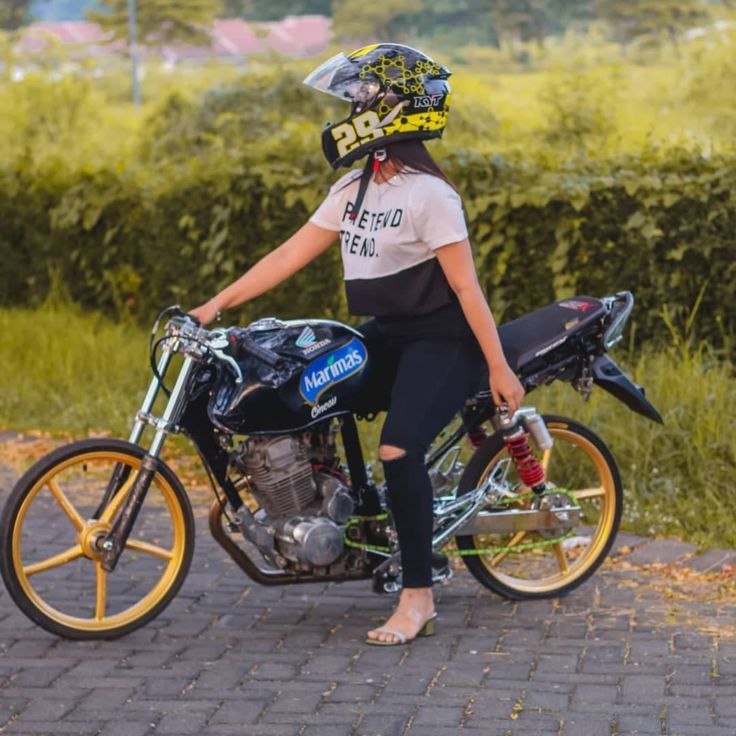 a woman sitting on top of a motorcycle