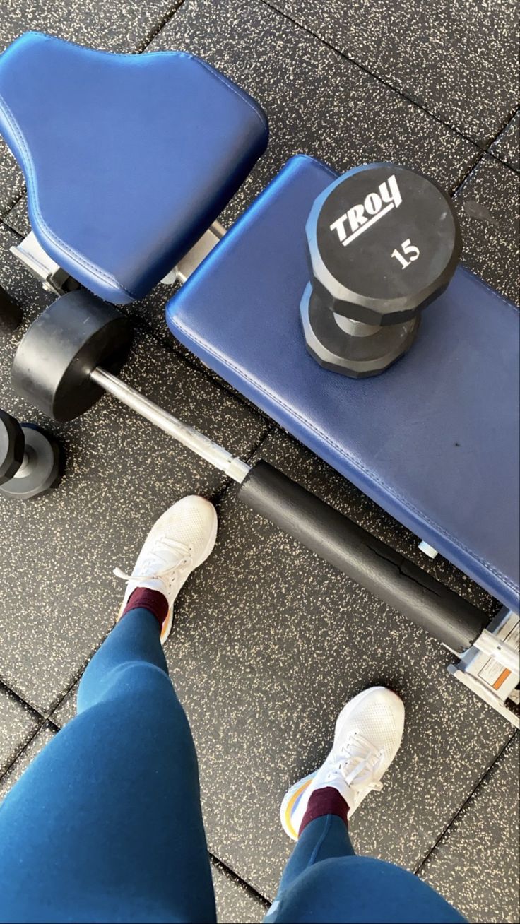 a person standing next to a blue bench with wheels on it and one foot in the air