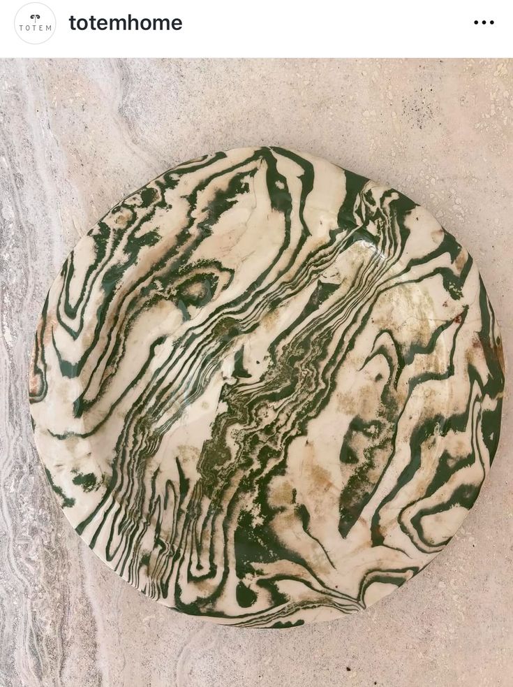 a white and green plate sitting on top of a cement floor next to a wall