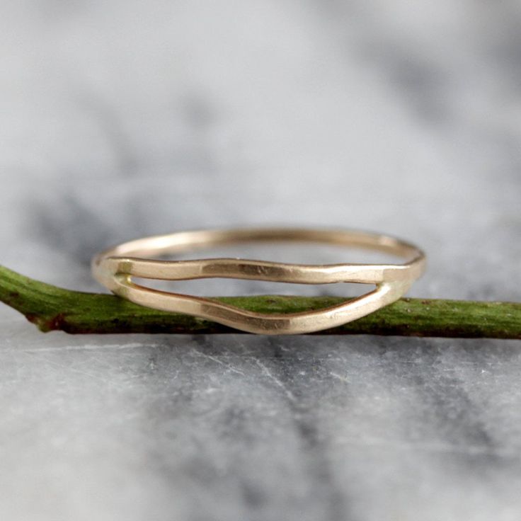 This delicate yet striking ring is made from one piece of hammered metal which wraps one and a half times around your finger, giving the appearance of two wavey stacking rings, yet maintaining the negative space between each band. The ring is wrapped and then soldered closed so it maintains both its shape and size. It has a lovely subtle hammered texture which adds dimension and sparkle. Available in sterling silver and 14k gold fill, as well as solid 14k gold in yellow and rose. sizes 5-9. All Stackable 14k Gold Bypass Ring With Open Band, 14k Gold Stackable Bypass Ring With Open Band, Hammered 14k Gold Open Stackable Rings, Modern Twist 14k Gold Double Band Rings, Modern Twist Double Band 14k Gold Rings, Stackable Open Band Rings In Recycled Gold, Minimalist 14k Gold Wavy Ring, 14k Gold Hand Forged Open Band Ring, Minimalist Silver Ring