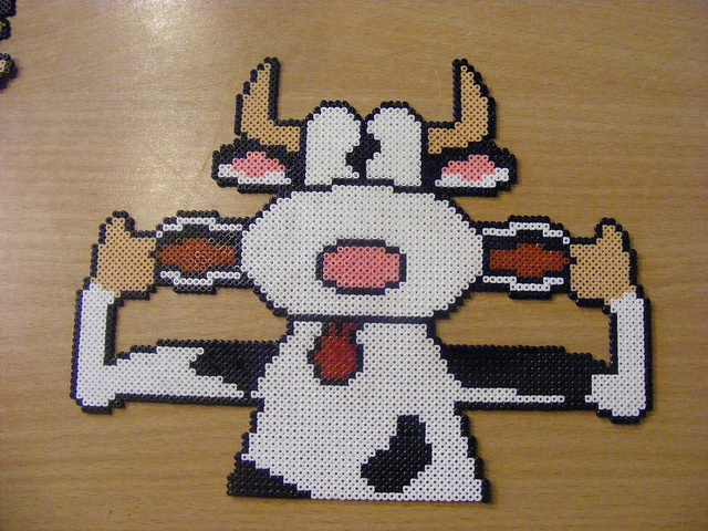 a cross - stitch pattern of a cow with two thumbs up and one hand in the air